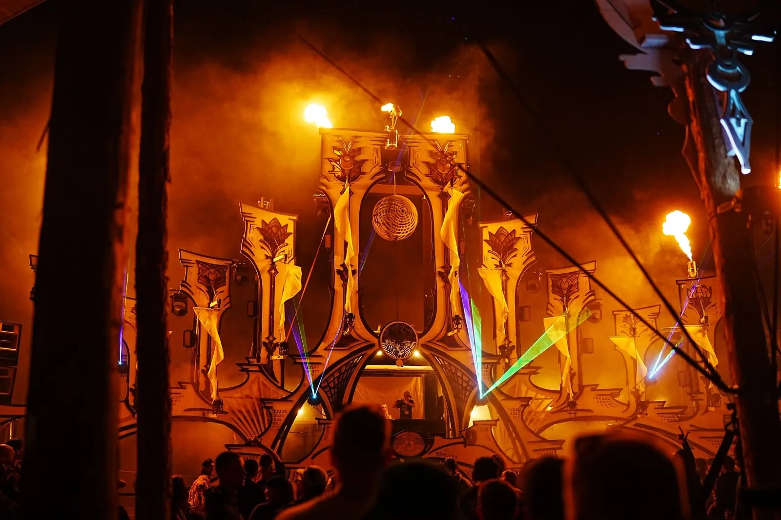 Feel Festival · Beach Stage 2026 – Die Strandbühne 2026 – ein Tempel aus ornamentalen Säulen, wehenden Tüchern und Feuer, vom Unterbau an als eine einzige Maschine geplant.